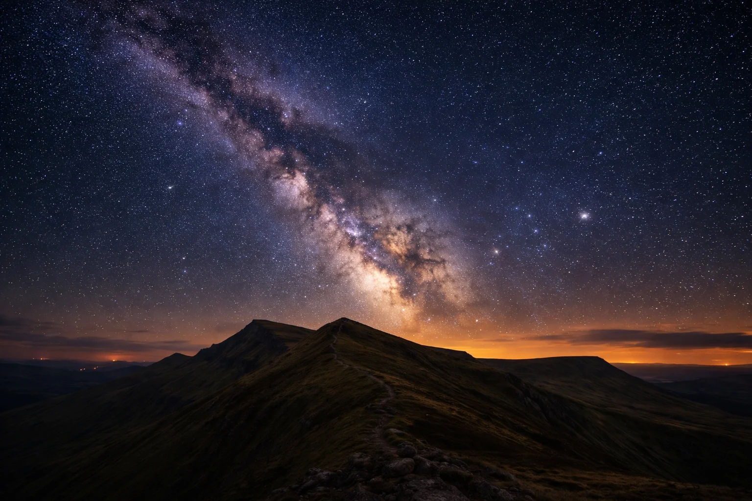 The Milky Way arching over a dark Brecon Beacons ridge line