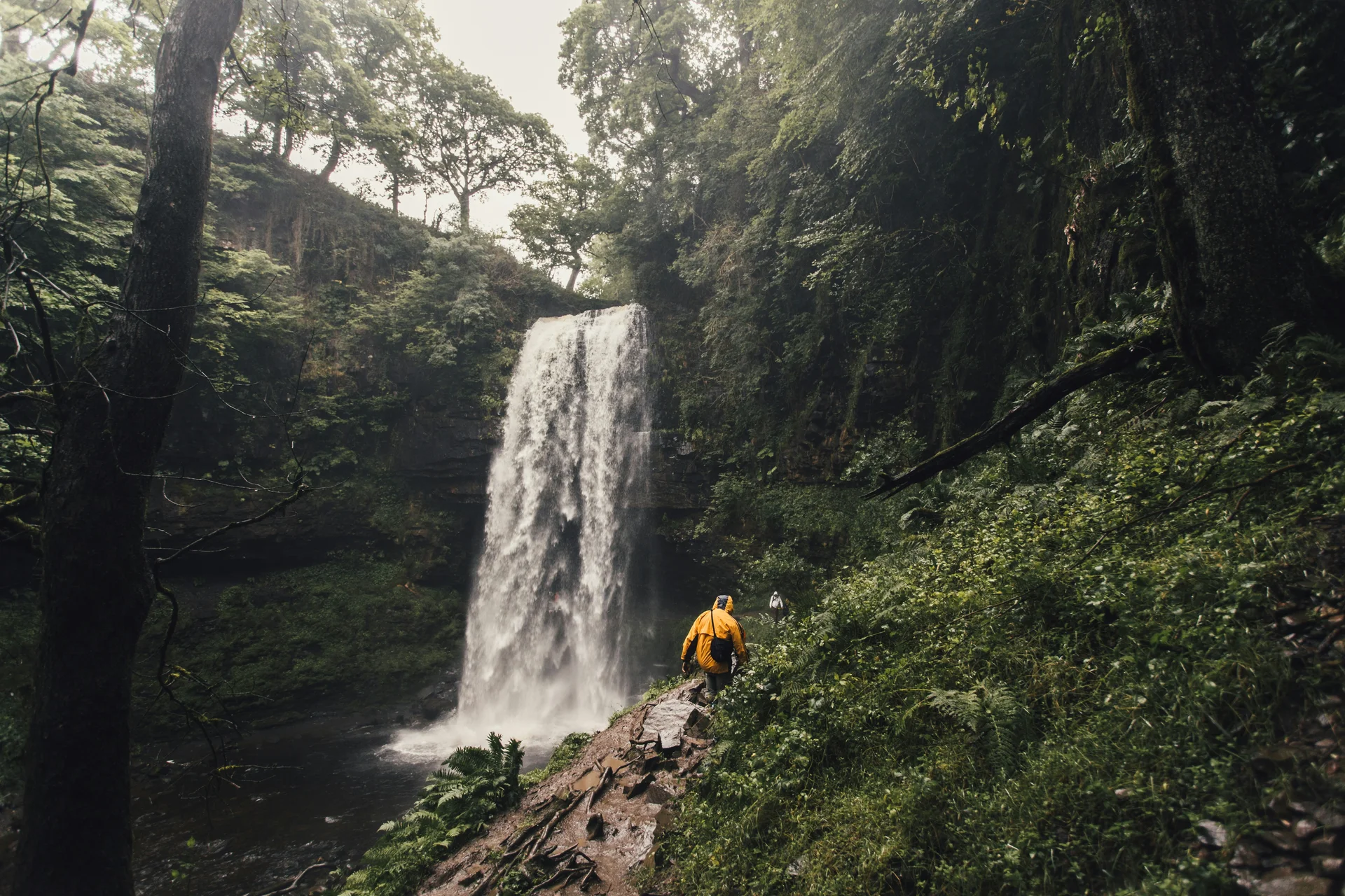 A hiker approaching one of the Four Waterfalls trail's cascades