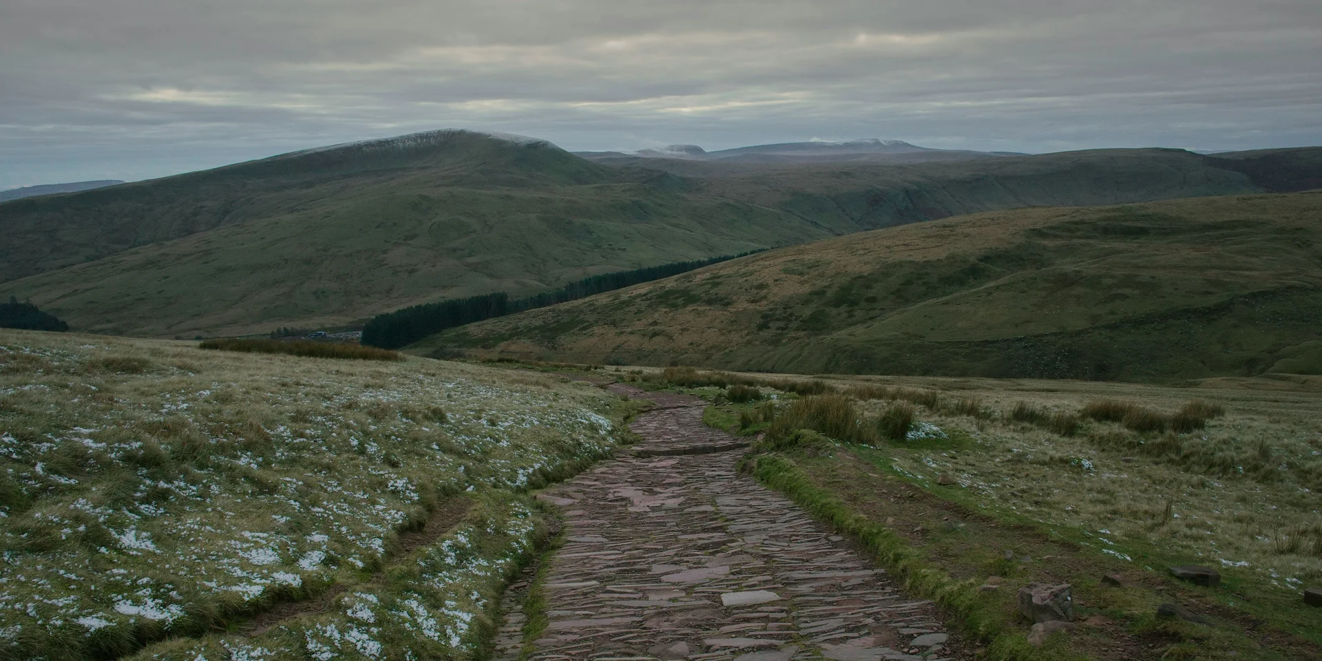 Stone summit path crossing the open plateau of the Brecon Beacons